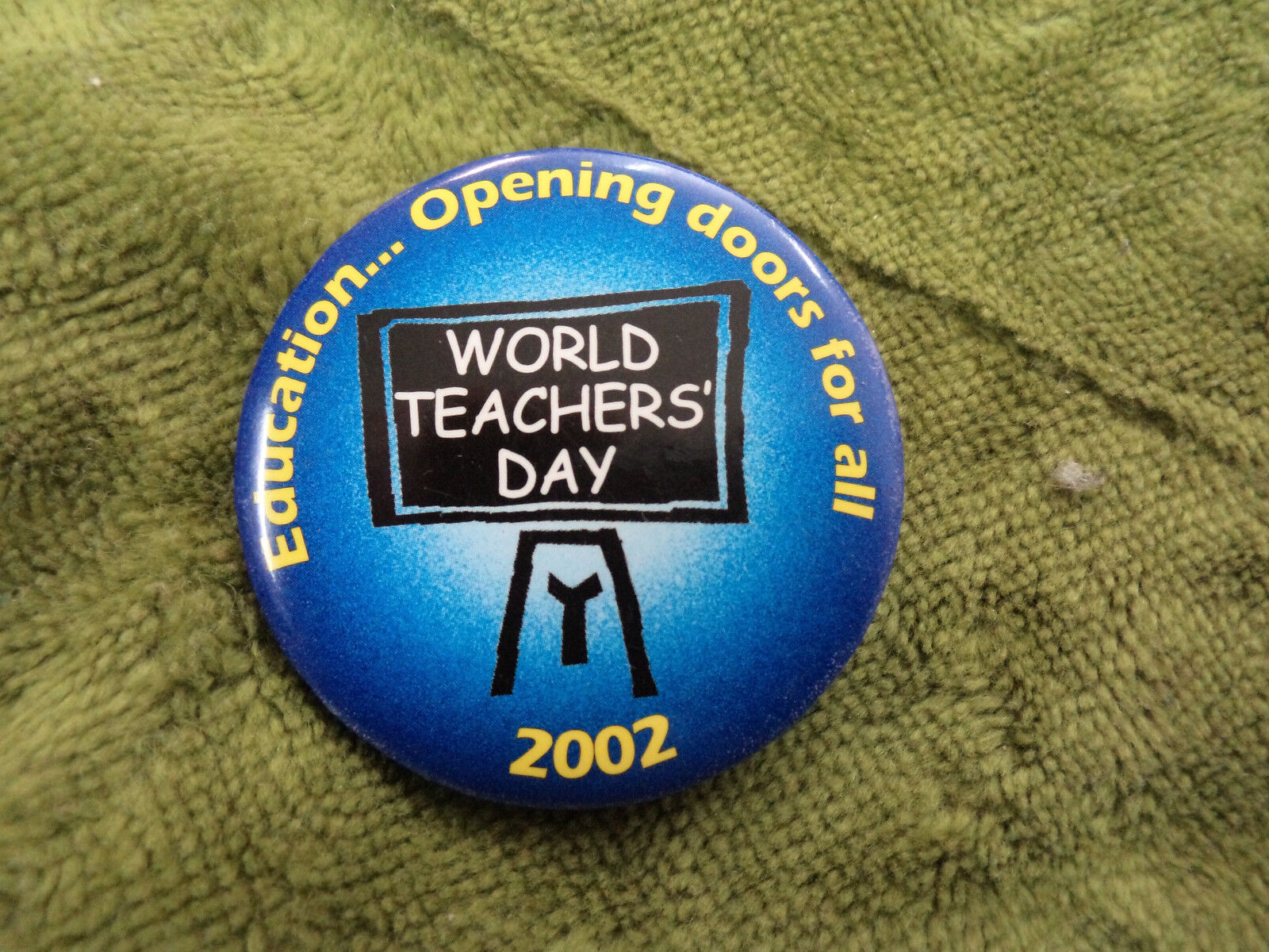 #D290. 2002   WORLD  TEACHERS'  DAY  TIN   BADGE